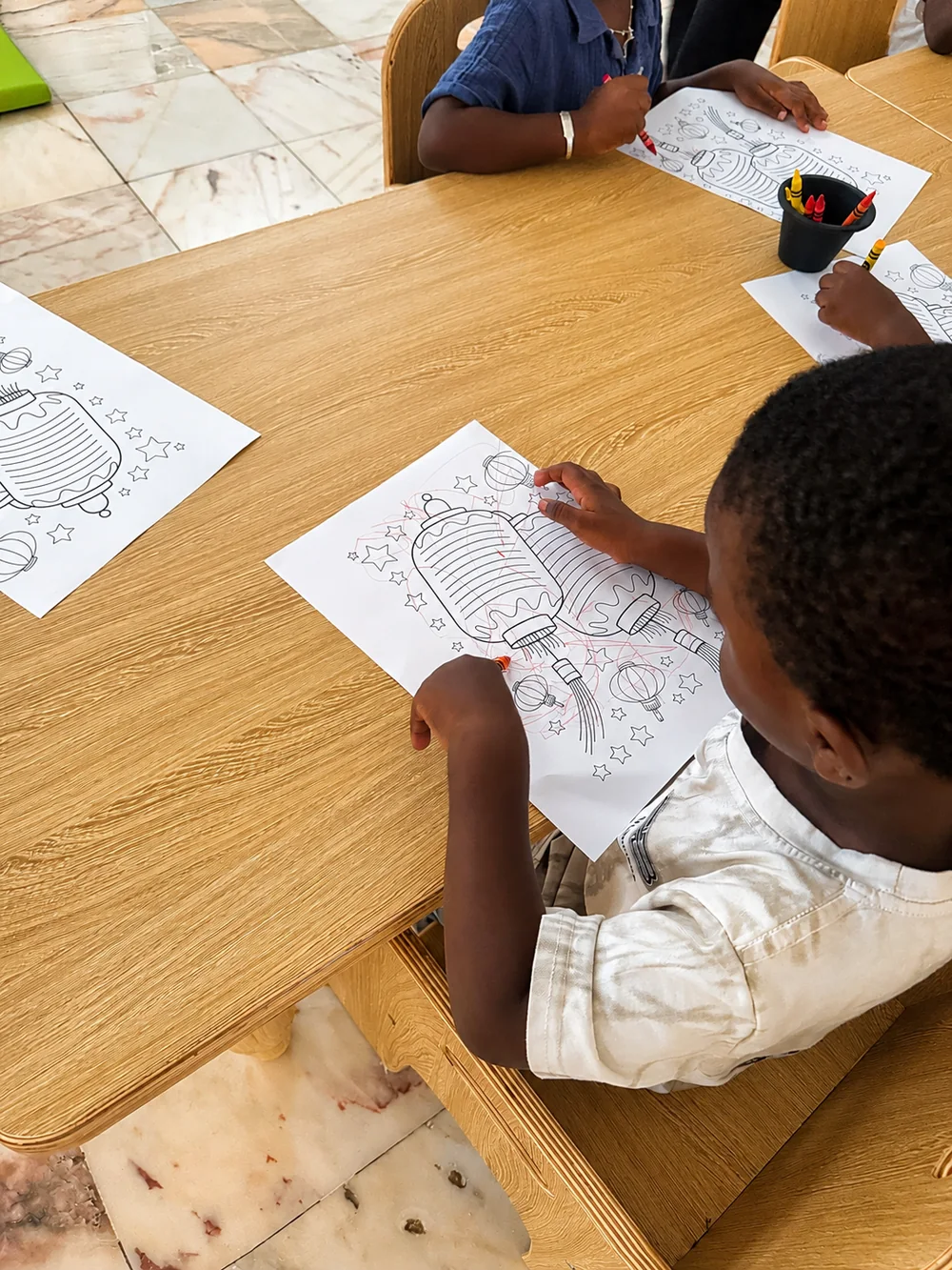 Enfant concentré sur une activité de coloriage en maternelle aux Petits Soleils